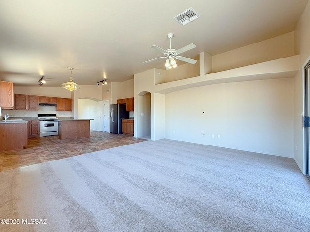 2582 W Brandy Crest Dr, Tucson, AZ 85713 - kitchen featuring stainless steel range, fridge with ice dispenser, open floor plan, arched walkways, and a sink