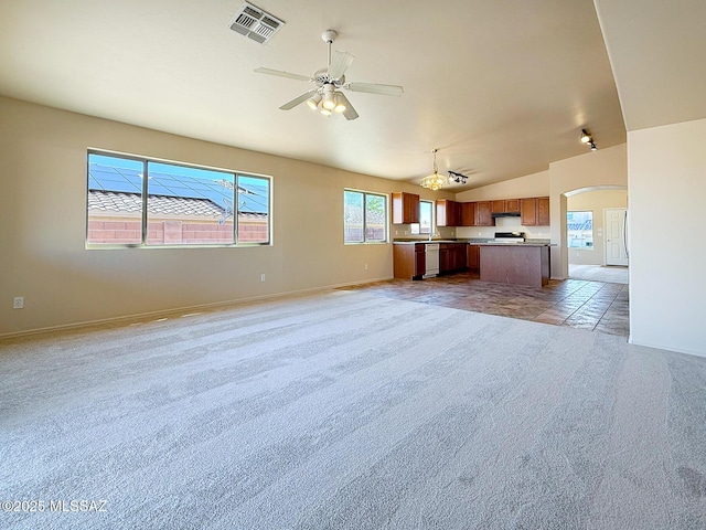 2582 W Brandy Crest Dr, Tucson, AZ 85713 - unfurnished living room with light colored carpet, arched walkways, a ceiling fan, lofted ceiling, and a chandelier