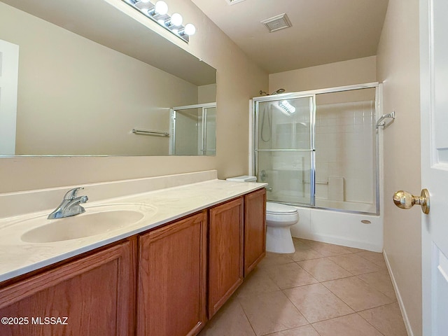 2582 W Brandy Crest Dr, Tucson, AZ 85713 - bathroom featuring vanity, tile patterned flooring, toilet, combined bath / shower with glass door, and baseboards
