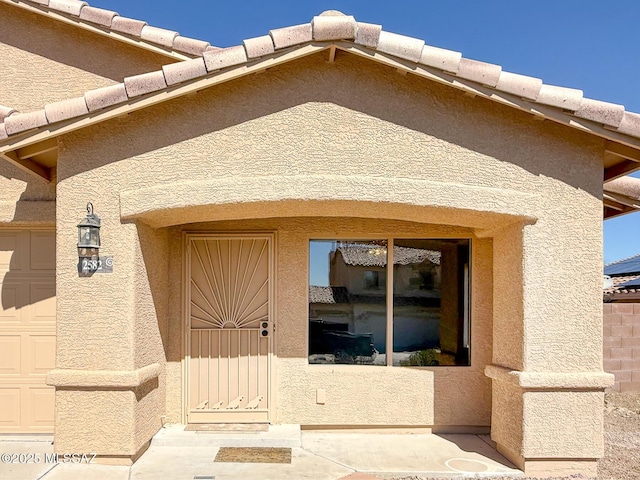 2582 W Brandy Crest Dr, Tucson, AZ 85713 - view of exterior entry featuring a garage and stucco siding