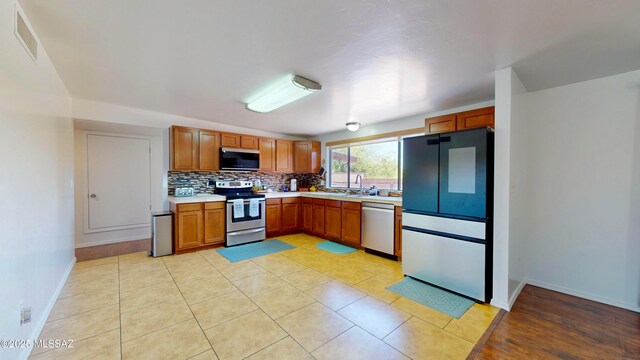 502 N Citadel Ave, Tucson, AZ 85748 - kitchen featuring tasteful backsplash, light countertops, baseboards, appliances with stainless steel finishes, and visible vents