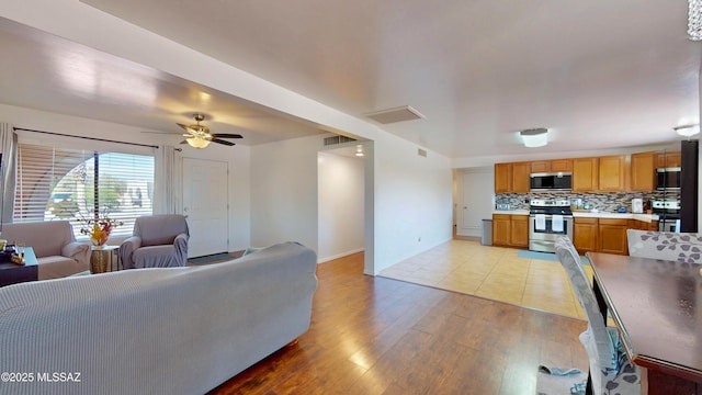 502 N Citadel Ave, Tucson, AZ 85748 - living room with baseboards, a ceiling fan, light wood-style floors, and visible vents