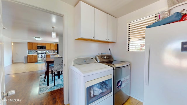 502 N Citadel Ave, Tucson, AZ 85748 - washroom with cabinet space, light wood-type flooring, and washer and dryer