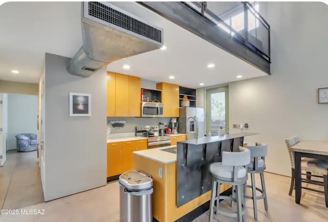 kitchen featuring open shelves, light countertops, an island with sink, stainless steel appliances, and recessed lighting