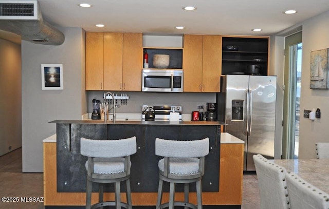 kitchen with open shelves, appliances with stainless steel finishes, a sink, recessed lighting, and a center island with sink