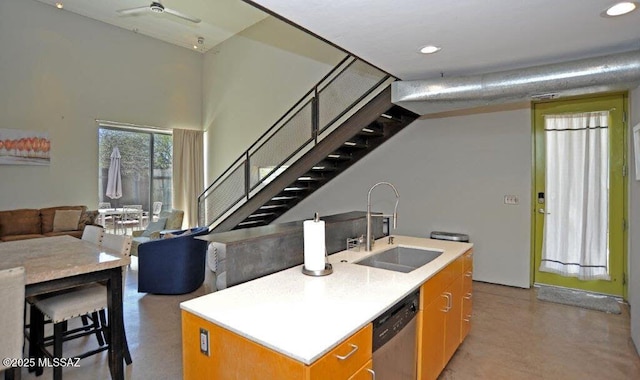 kitchen with stainless steel dishwasher, a center island with sink, a sink, open floor plan, and recessed lighting