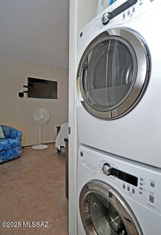 clothes washing area with stacked washer and dryer and laundry area