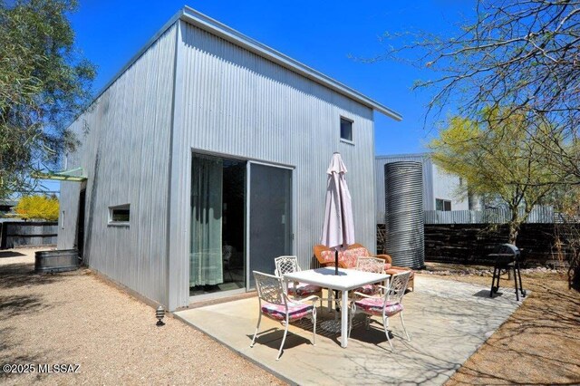 back of house featuring fence, outdoor dining area, and a patio area