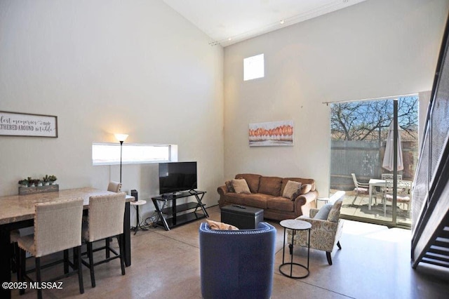 living area with a high ceiling and concrete flooring