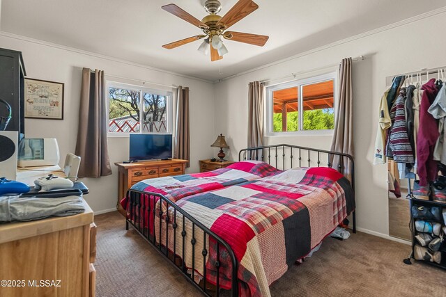 carpeted bedroom with crown molding, a ceiling fan, baseboards, and multiple windows