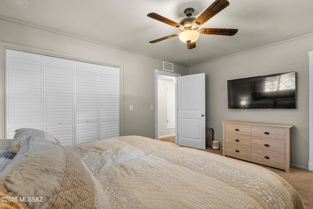 bedroom with a closet, ceiling fan, light colored carpet, ornamental molding, and visible vents