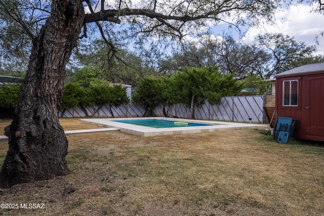 view of swimming pool featuring an outdoor structure, a lawn, a shed, and a fenced backyard