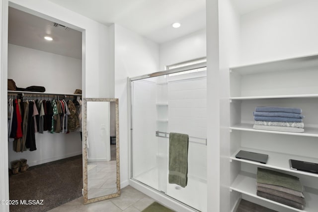 bathroom with recessed lighting, tile patterned flooring, a shower stall, a walk in closet, and visible vents