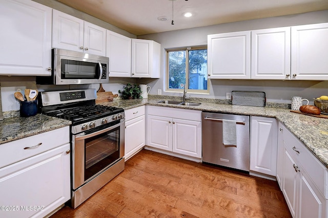 kitchen with white cabinets, appliances with stainless steel finishes, and a sink