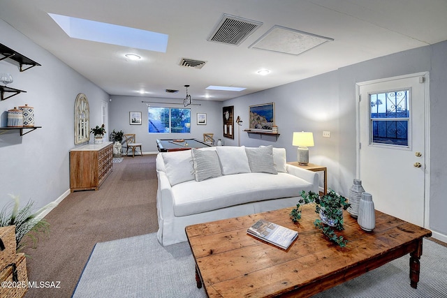 living area featuring baseboards, visible vents, carpet flooring, and a skylight