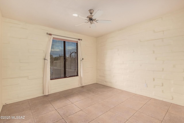 spare room with a ceiling fan and light tile patterned floors