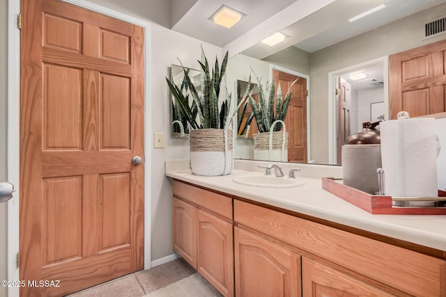 bathroom with baseboards, visible vents, tile patterned flooring, and vanity