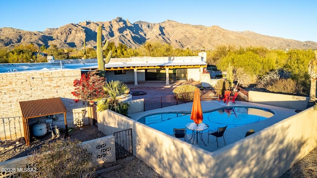 view of pool with a fenced backyard, a fenced in pool, a mountain view, and a patio
