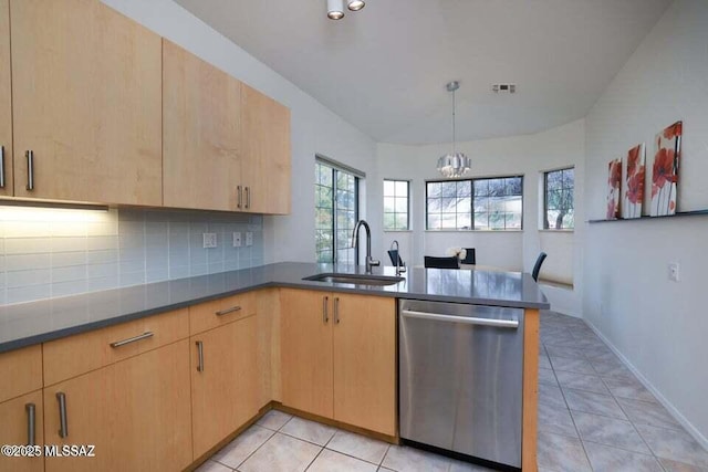 kitchen with a peninsula, stainless steel dishwasher, light brown cabinetry, and a sink