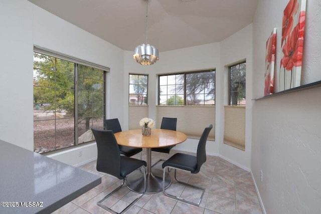 dining room with light tile patterned flooring, baseboards, and a notable chandelier