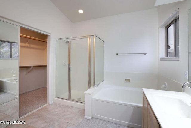 full bath featuring a shower stall, tile patterned floors, a walk in closet, a bath, and vanity