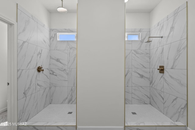 full bath with baseboards, a wealth of natural light, and tiled shower