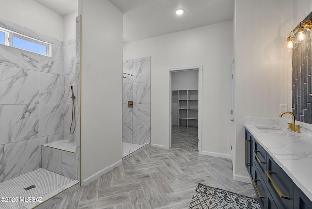full bath with recessed lighting, vanity, baseboards, and a marble finish shower