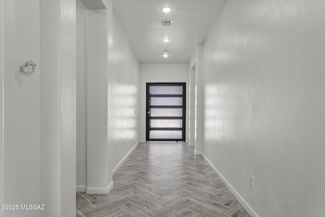 hall with visible vents and baseboards