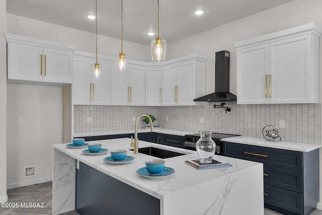 kitchen with wall chimney exhaust hood, white cabinets, a sink, electric range, and light stone counters