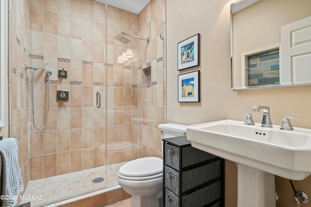 bathroom with a shower stall and toilet