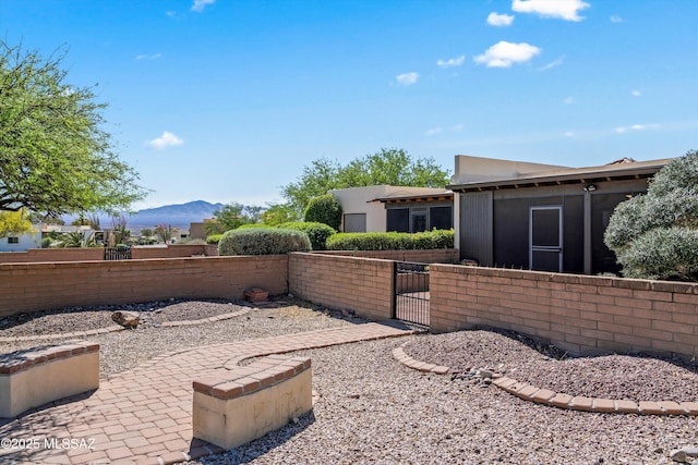 view of yard featuring a gate, a mountain view, and a fenced front yard