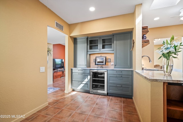 bar with tile patterned floors, wine cooler, a sink, visible vents, and baseboards