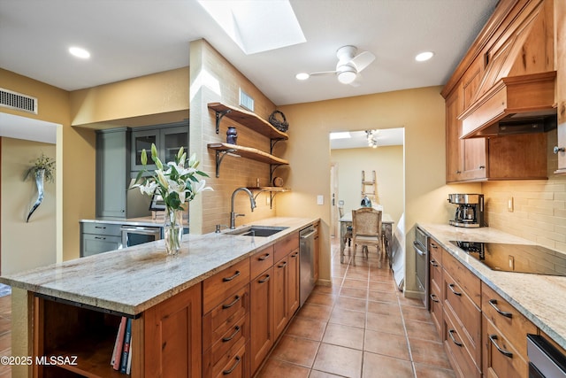 kitchen with open shelves, a sink, a skylight, decorative backsplash, and appliances with stainless steel finishes