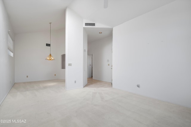 unfurnished room with arched walkways, visible vents, light colored carpet, ceiling fan, and high vaulted ceiling