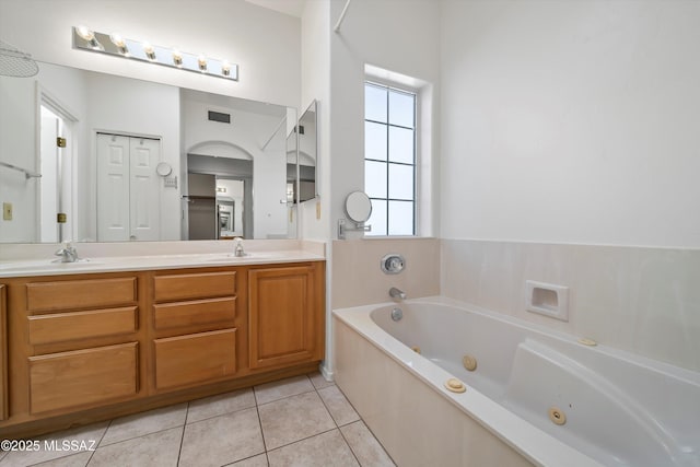 bathroom featuring tile patterned floors, a sink, double vanity, visible vents, and a tub with jets