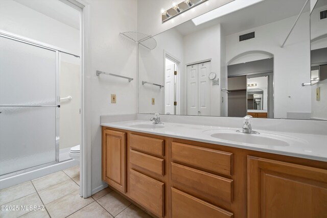 full bathroom featuring tile patterned floors, visible vents, a sink, and a shower stall