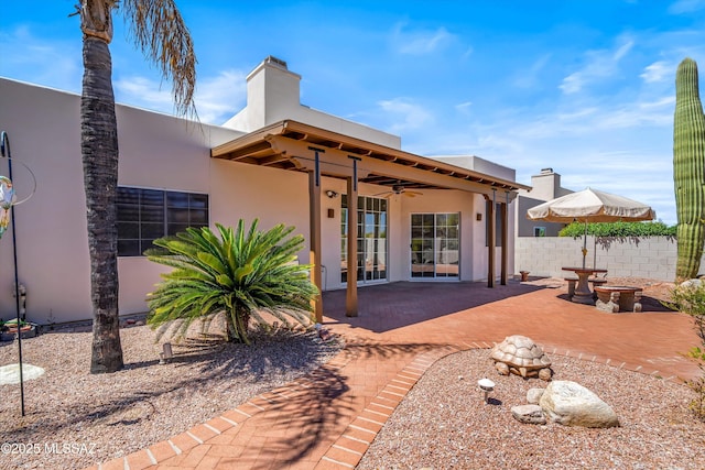 rear view of house with fence, a patio area, ceiling fan, stucco siding, and french doors