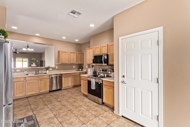 kitchen featuring a sink, light brown cabinetry, light tile patterned floors, stainless steel appliances, and light countertops