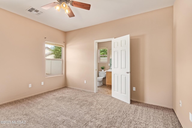 empty room featuring visible vents, light carpet, baseboards, and ceiling fan
