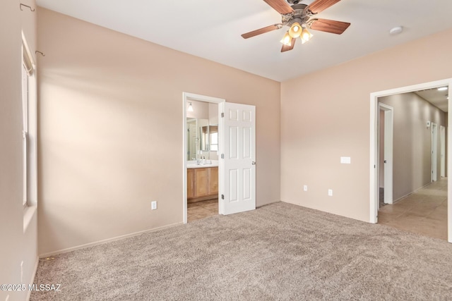 unfurnished bedroom featuring light carpet, connected bathroom, and ceiling fan