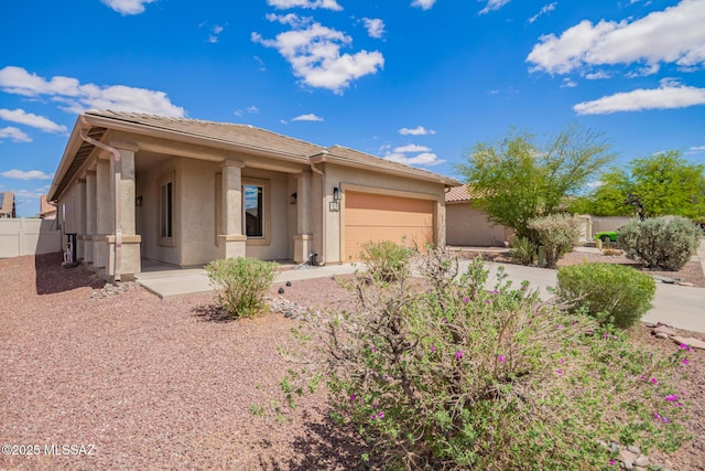 view of front of house featuring driveway, a tiled roof, fence, a garage, and stucco siding