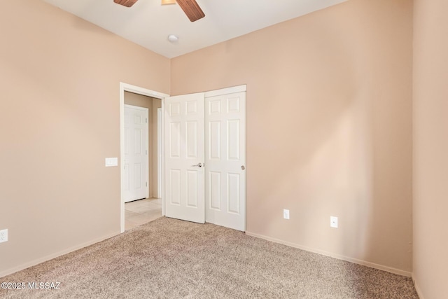 unfurnished bedroom with baseboards, carpet floors, a closet, and ceiling fan