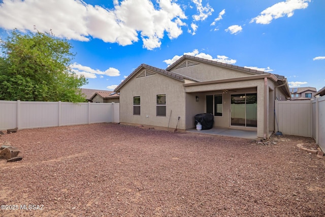 back of house with a patio area, a fenced backyard, and stucco siding