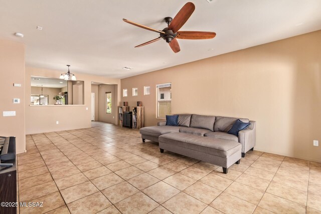 living room featuring light tile patterned floors and ceiling fan with notable chandelier