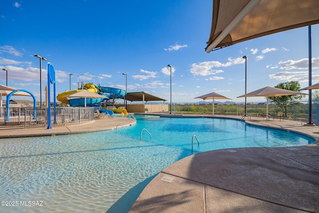 community pool with a water slide and fence