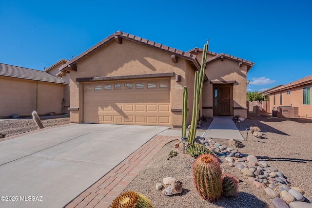 view of front facade with concrete driveway, fence, stucco siding, and a garage
