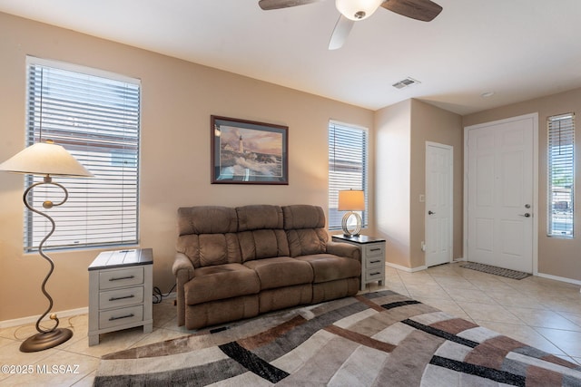 living area featuring baseboards, a healthy amount of sunlight, visible vents, and light tile patterned floors