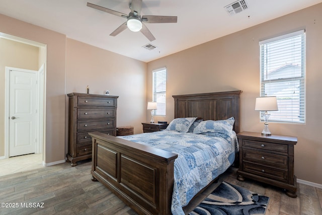 bedroom with visible vents, light wood finished floors, baseboards, and a ceiling fan