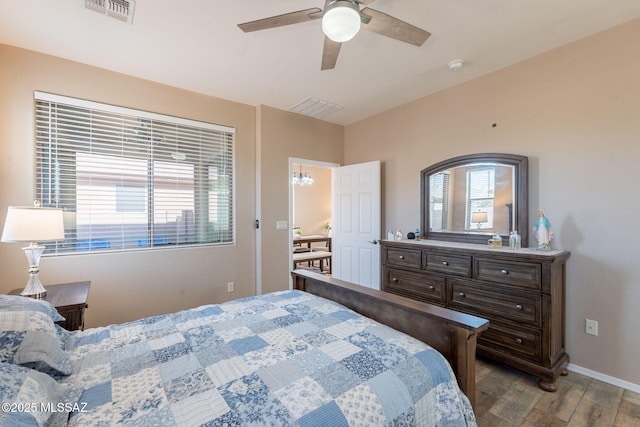 bedroom featuring baseboards, wood finished floors, visible vents, and a ceiling fan