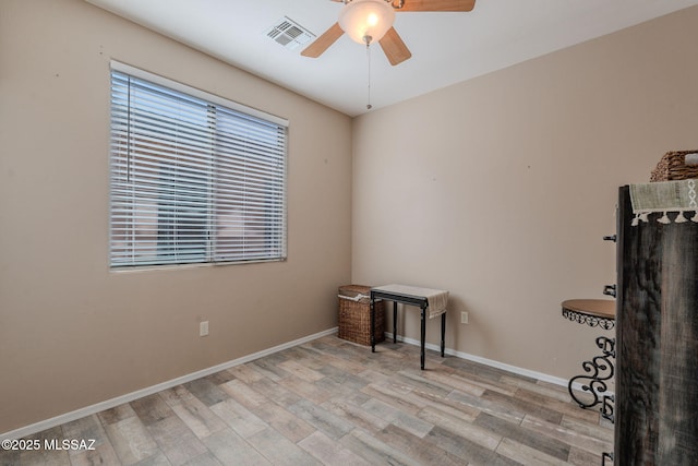 interior space with wood finished floors, visible vents, baseboards, and ceiling fan